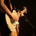 person standing while playing guitar